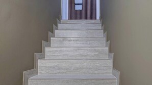 Una escalera que lleva a una puerta con un ventanal encima.