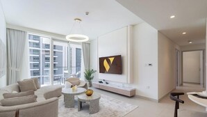 Una sala de estar moderna con sofá, mesa de centro y televisor.