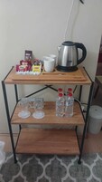 Una estantería de madera con una tetera, tazas y alimentos.