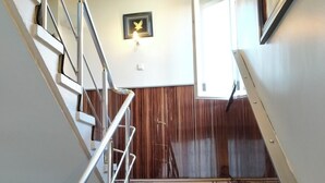 A staircase with a patterned carpet, metal railings, and a wooden wall. - Ari Otel (Erzurum)