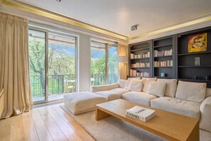 A modern living room with a sectional sofa, a coffee table, and a bookshelf. - Superb 2 bdr Apartment Terrace Neuilly-sur-seine (Neuilly-sur-Seine)