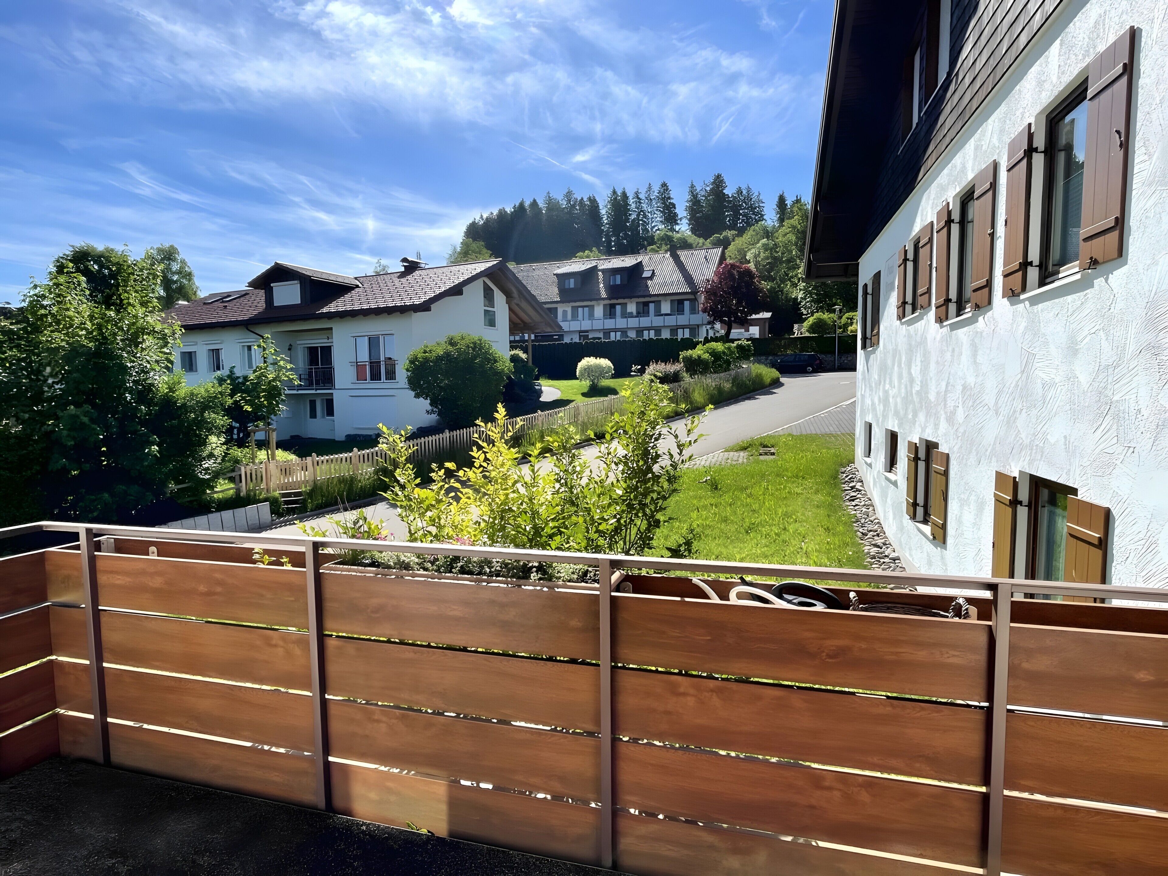 Ein Wohngebiet mit Häusern, einem Holzzaun und blauem Himmel.