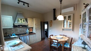 A kitchen with a stove, sink, and dining table with chairs.