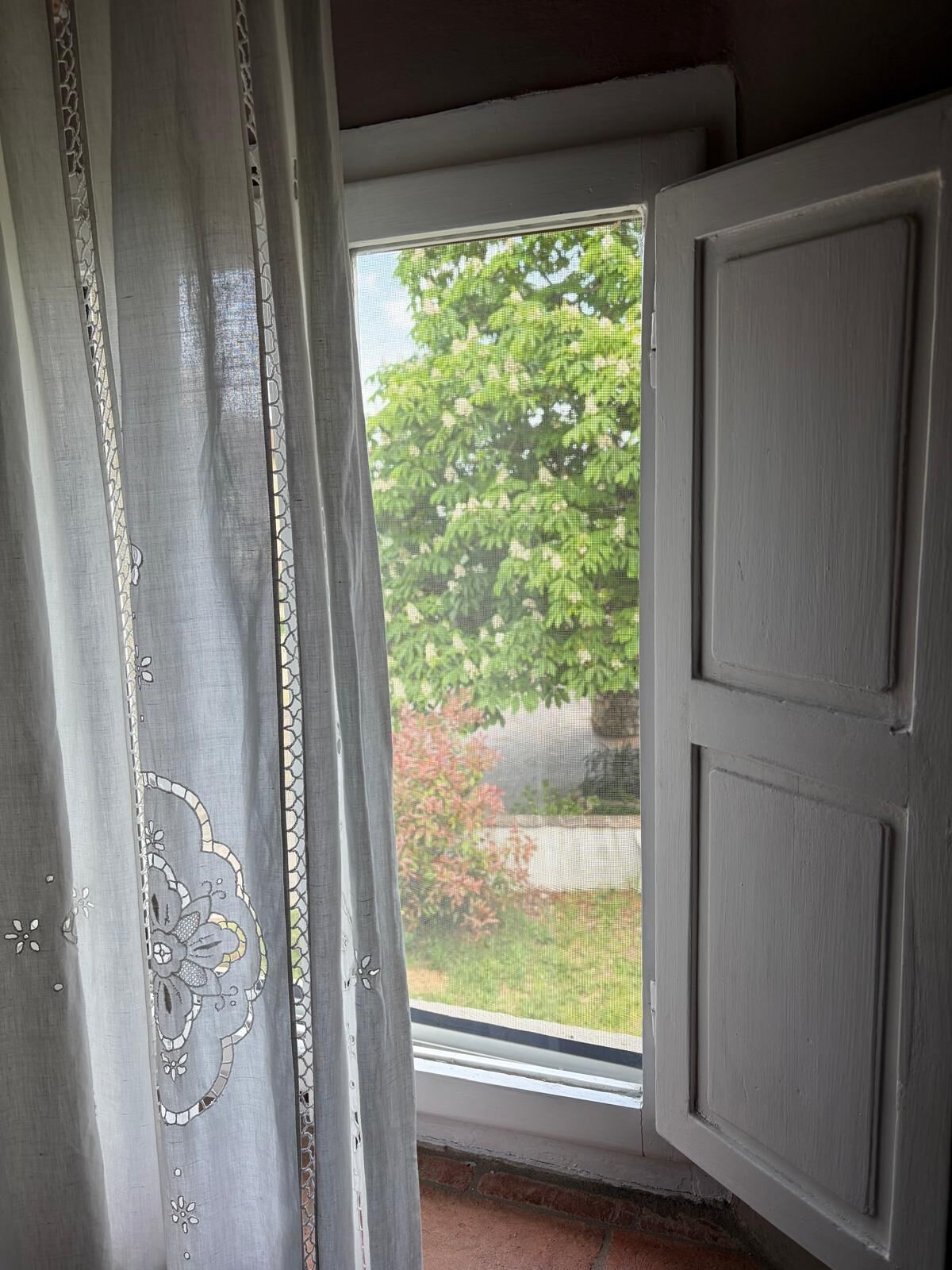 Une pièce avec une fenêtre, une porte et une vue sur la verdure.