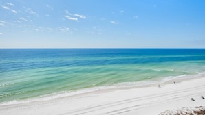Ein Strand mit klarem türkisblauem Wasser und einem sandigen Ufer.