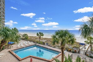 A pool area with a view of the beach and ocean, surrounded by palm trees and lounge chairs. - Wrap around Views! Newly Remodeled 9th Floor 3BR 3BA Commodore *BEACH CHAIRS! (Panama City Beach)