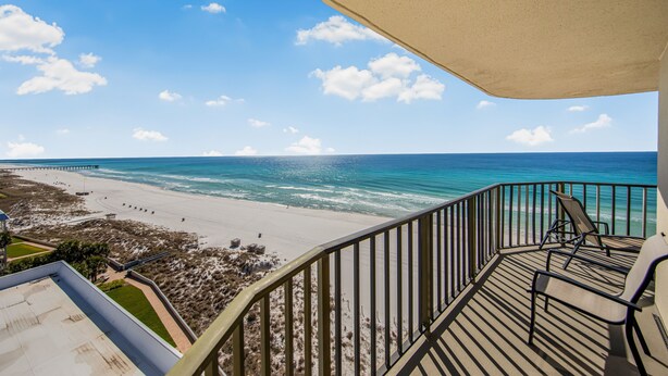 Ein Balkon mit Blick auf Strand und Meer.