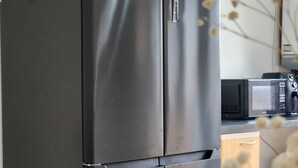 A black refrigerator in a kitchen with a microwave and wooden cabinets. - Birmingham Contractor Stay, 5 Bed, Private Parking, Near M6, Groups (Birmingham)