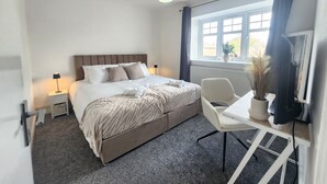 A bedroom with a bed, bedside tables, a chair, a window, and a lamp. - Birmingham Contractor Stay, 5 Bed, Private Parking, Near M6, Groups (Birmingham)
