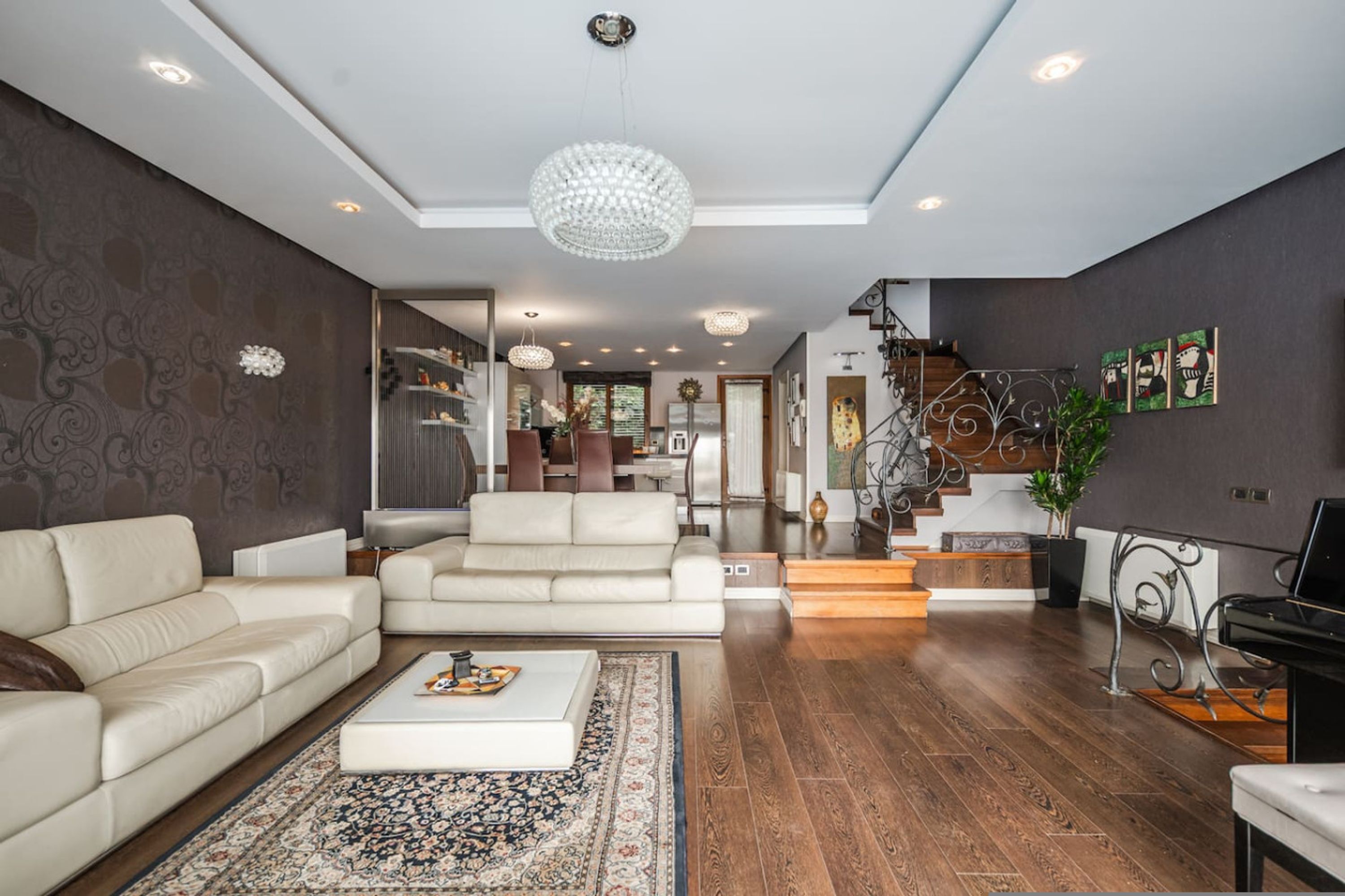A modern living room with a sofa, coffee table, and a chandelier.