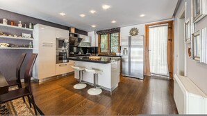 A modern kitchen with a central island, bar stools, and built-in appliances. - Tranquility Villa With Pool Private Garden BBQ (Farkë)