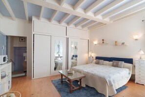 A bedroom with a bed, bedside tables, a wardrobe, a mirror, and a small table.