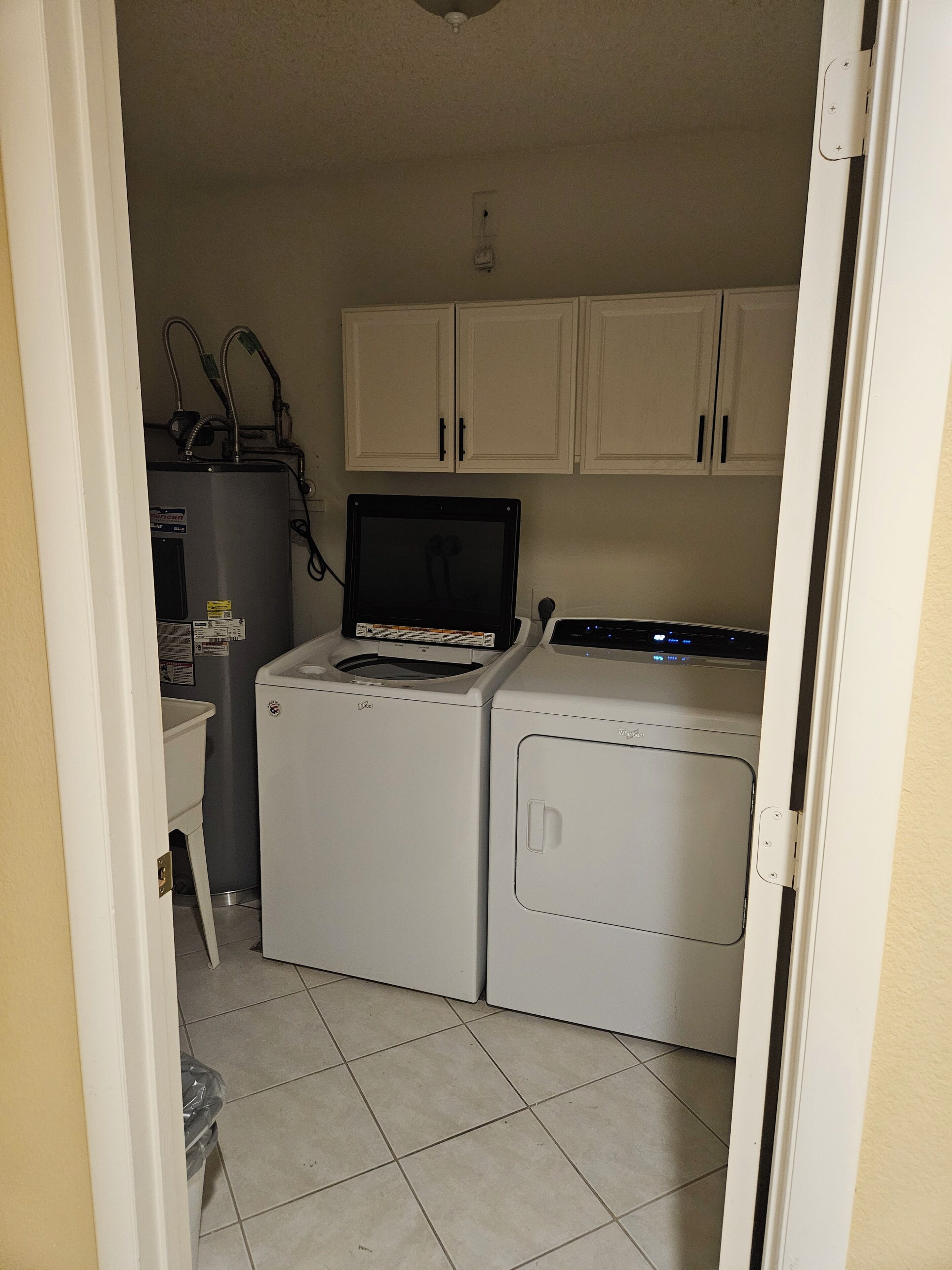 A laundry room with a washer, dryer, and water heater.