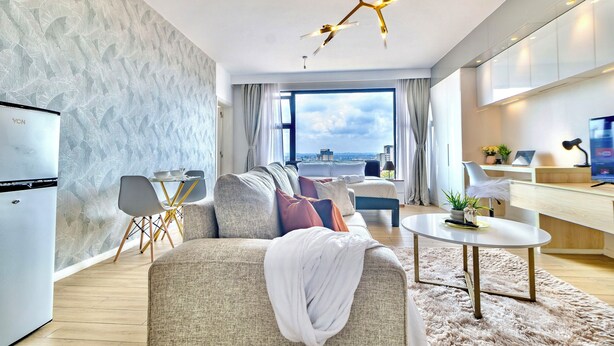 Ein modernes Wohnzimmer mit Sofa, Esstisch und Küchenzeile.