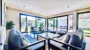 A modern outdoor living area with a sofa, chairs, and a table. - Stunning studio with city views steps from the Junction Mall (Nairobi)