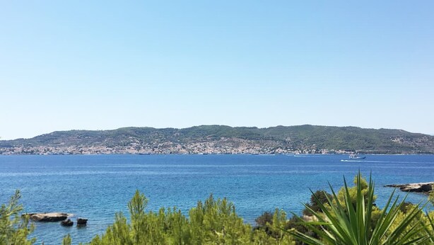 Un paisaje costero con vista despejada al mar, una costa lejana y un barco.