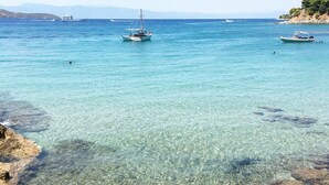 Una vista costera despejada con barcos en el agua y un litoral rocoso.