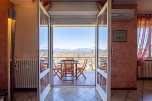 Ein Zimmer mit einer Schiebetür und einem Balkon mit Tisch und Stühlen.