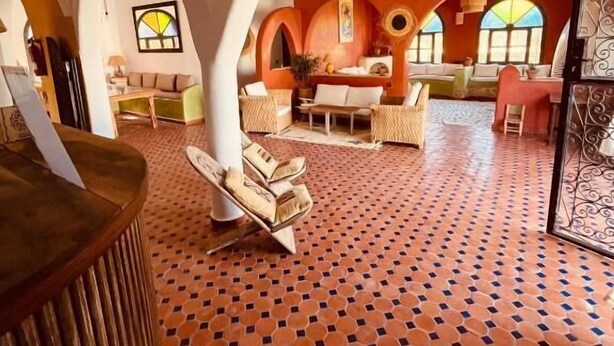 An interior with arched ceilings, a patterned floor, and a central seating area with a table and chairs. - Villa Nouran (Ghazoua)