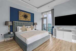 A modern bedroom with a large bed, a TV, and a balcony view. - 3BR + Maid's Room | Al Habtoor City | Pool & Gym (Business Bay)