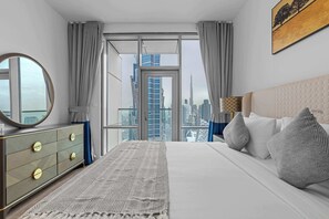 Ein modernes Hotelzimmer mit einem großen Bett, einem Schminktisch, einem Spiegel und Blick auf eine Stadtlandschaft.