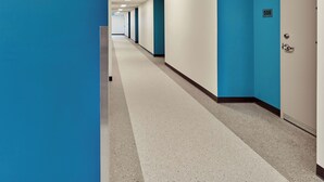 A long, narrow hallway with blue walls and white doors, leading to a room with a door labeled '508'.