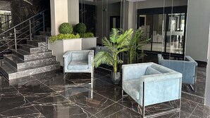 Eine moderne Lobby mit Marmorböden, einer Treppe und Sitzbereichen.