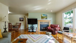 Una sala de estar con chimenea, televisor y comedor.
