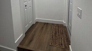 A hallway with a wooden floor, a rug, a framed picture on the wall, and white doors. - Super comfortable Studio in Margate. Host is amazing!!!! (Margate)