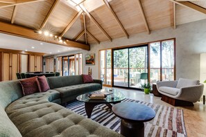 A spacious living area with a large sectional sofa, a glass coffee table, and a comfortable armchair.