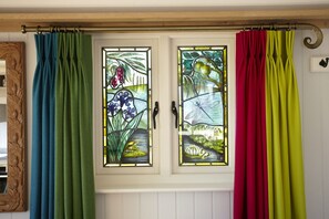 A window with stained glass depicting flowers and fruits.