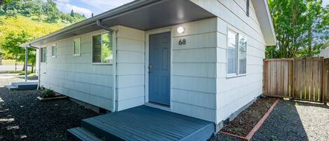 Une maison mobile de plain-pied, dotée d’un porche à l’avant, d’une petite terrasse et du numéro « 68 » sur la porte.