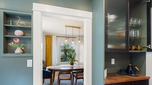 A modern kitchen with a wooden countertop, a dining area with a table and chairs, and a view through a window. - Orchard Luxe - Modern Home In Walking Distance To Uo 3 Bedroom Home (Eugene)