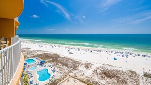 A beach resort with a pool area, beach chairs, and umbrellas. - Phoenix Gulf Towers 1005 4 Bedroom Condo (Orange Beach)