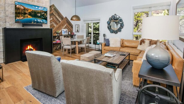 A modern living room with a fireplace, comfortable seating, a television, and a view of the outdoors. - Coldstream #18 3 Bedroom Townhouse (Vail)