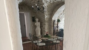 Ein Essbereich mit Terrazzoboden, weißen Wänden und einem Sandsteinbogen.