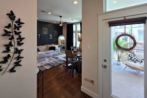 A modern living room with a sofa, a dining table, and a decorative wall piece. - Wonderland 3bd Escape Near Downtown Houston (Houston)