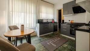 Een moderne keuken met een eetgedeelte, met een ronde tafel, stoelen en een kookeiland.