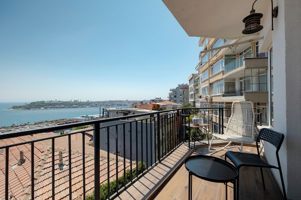 Ein Balkon mit Meerblick, einem Tisch und zwei Stühlen.