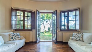 A room with two white sofas, a wooden floor, and a view through a large window. - Villa Krizia - Ancona, beautifull villa with sea view pool (Ancona)