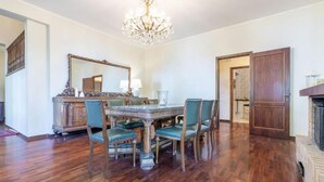 A dining room with a wooden table, chairs, a chandelier, and a mirror on the wall. - Villa Krizia - Ancona, beautifull villa with sea view pool (Ancona)