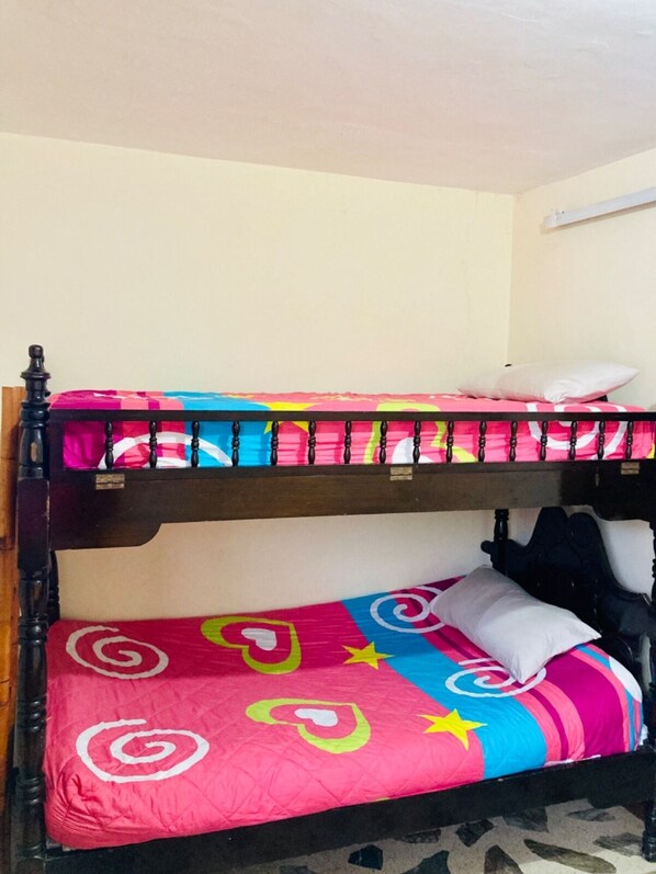 A bunk bed with a colorful bedspread and a white pillow. - Room-hotel Casa Del Pueblo (Jardin)