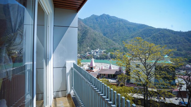 Un balcón con vistas a un paisaje montañoso y una masa de agua.