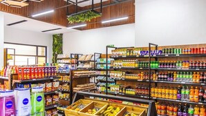 Ein Supermarktinnenraum mit Regalen voller Waren, einer Bananenauslage und einer Holzkiste.