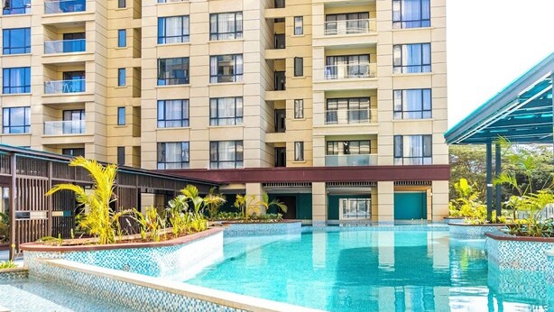 Ein Hotel mit Schwimmbad, überdachtem Bereich und einem mehrstöckigen Gebäude mit Balkonen.