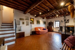 A spacious room with a wooden staircase, a sofa, a fireplace, and a dining area. - Charming 160 square meters apartment, perfect for six people, located on the first floor of a recently renovated medieval convent (no elevator).The property is located in Monti, a hamlet of Gaiole in Chianti: the area is extremely quiet and surrounded by (Monti)