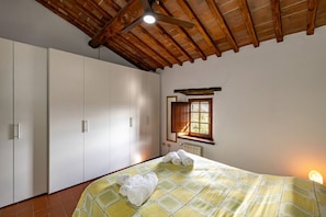A bedroom with a bed, a window, and a ceiling fan. - Charming 160 square meters apartment, perfect for six people, located on the first floor of a recently renovated medieval convent (no elevator).The property is located in Monti, a hamlet of Gaiole in Chianti: the area is extremely quiet and surrounded by (Monti)