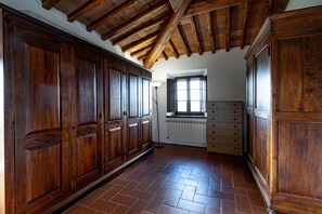 Ein Zimmer mit Holzausstattung, Fliesenboden, einem Fenster mit Jalousien und einem Heizkörper.