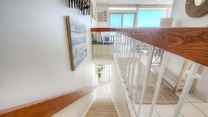 Una escalera con barandilla de madera que lleva a un balcón.