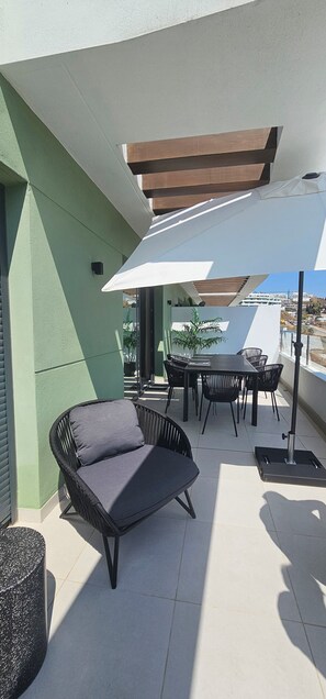 Eine Terrasse im Freien mit Tisch, Stühlen und einer gepolsterten Sitzecke.